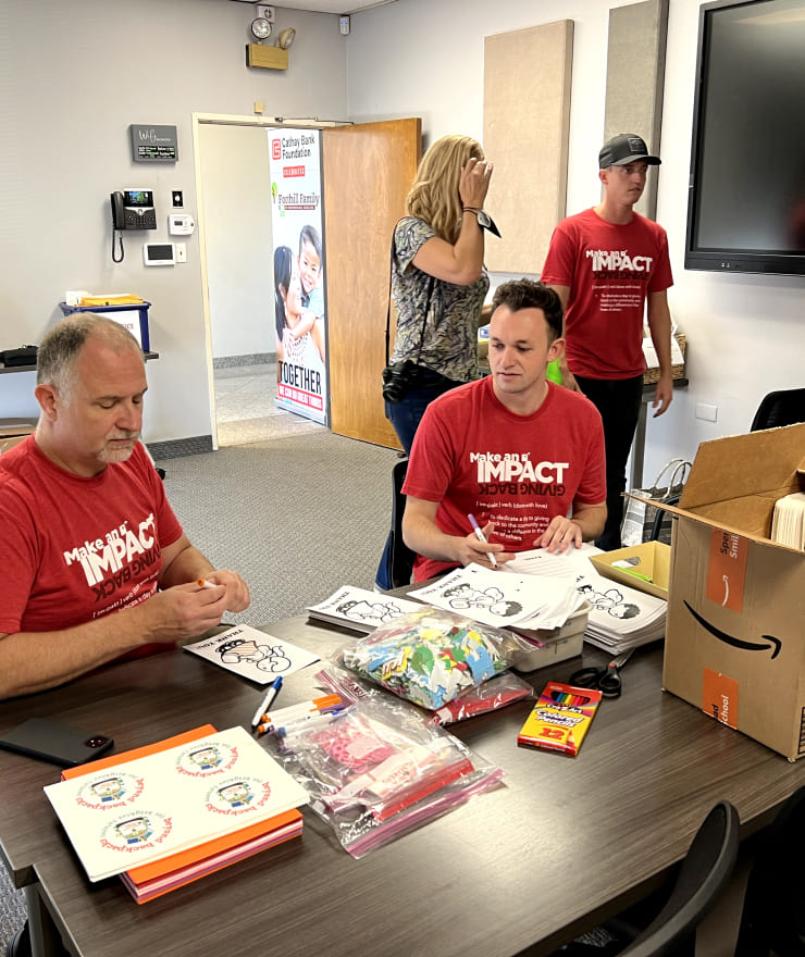 people in room preparing charity packages at table