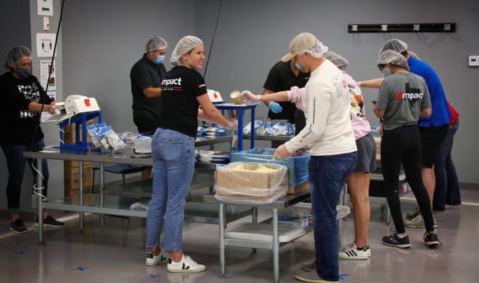 Employees wearing impact clothing working at a food donation warehouse 
